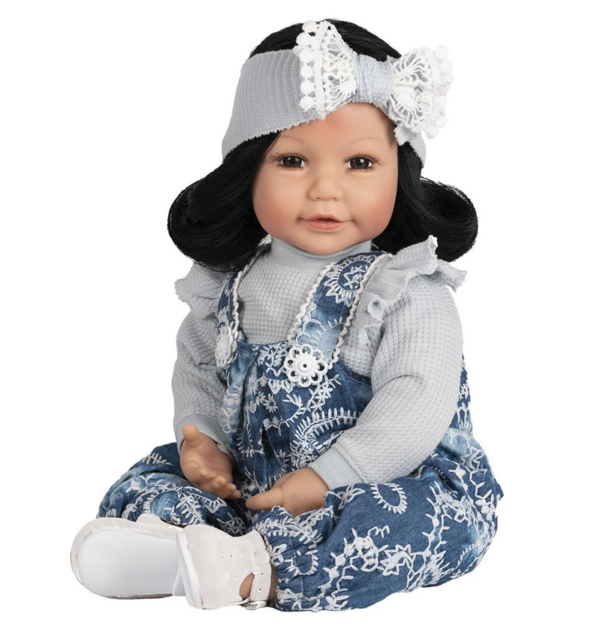 Dementia therapy doll wearing a blue floral dress with white lace