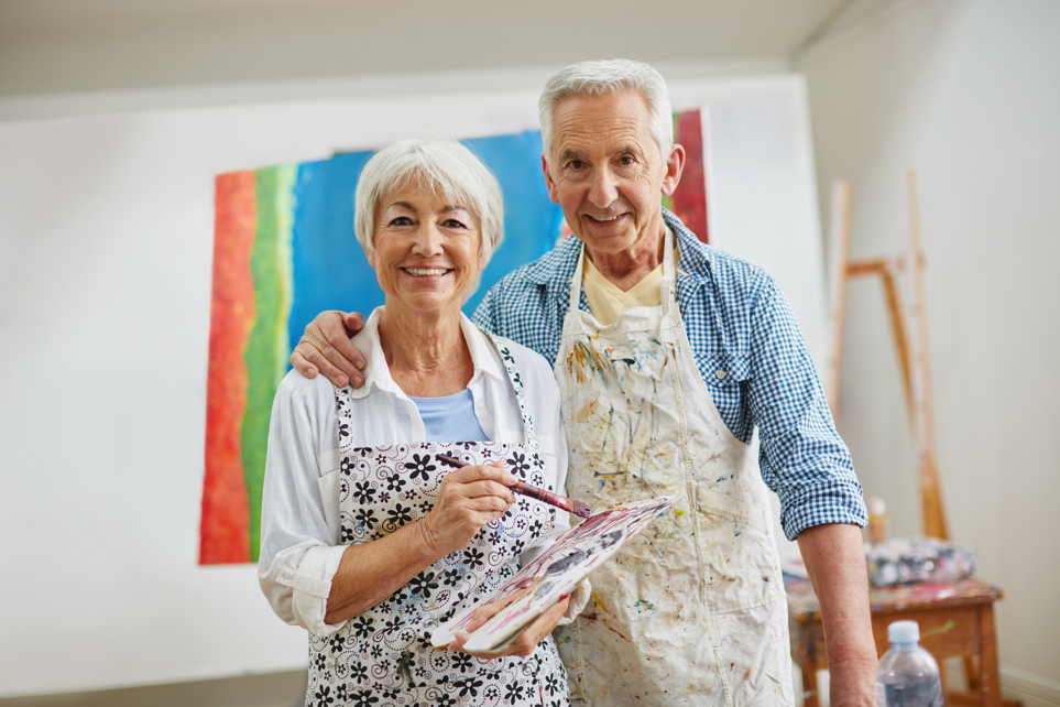 Senior couple in an art studio with painting supplies