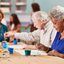 Group of elderly people engaged in an art activity at a table.