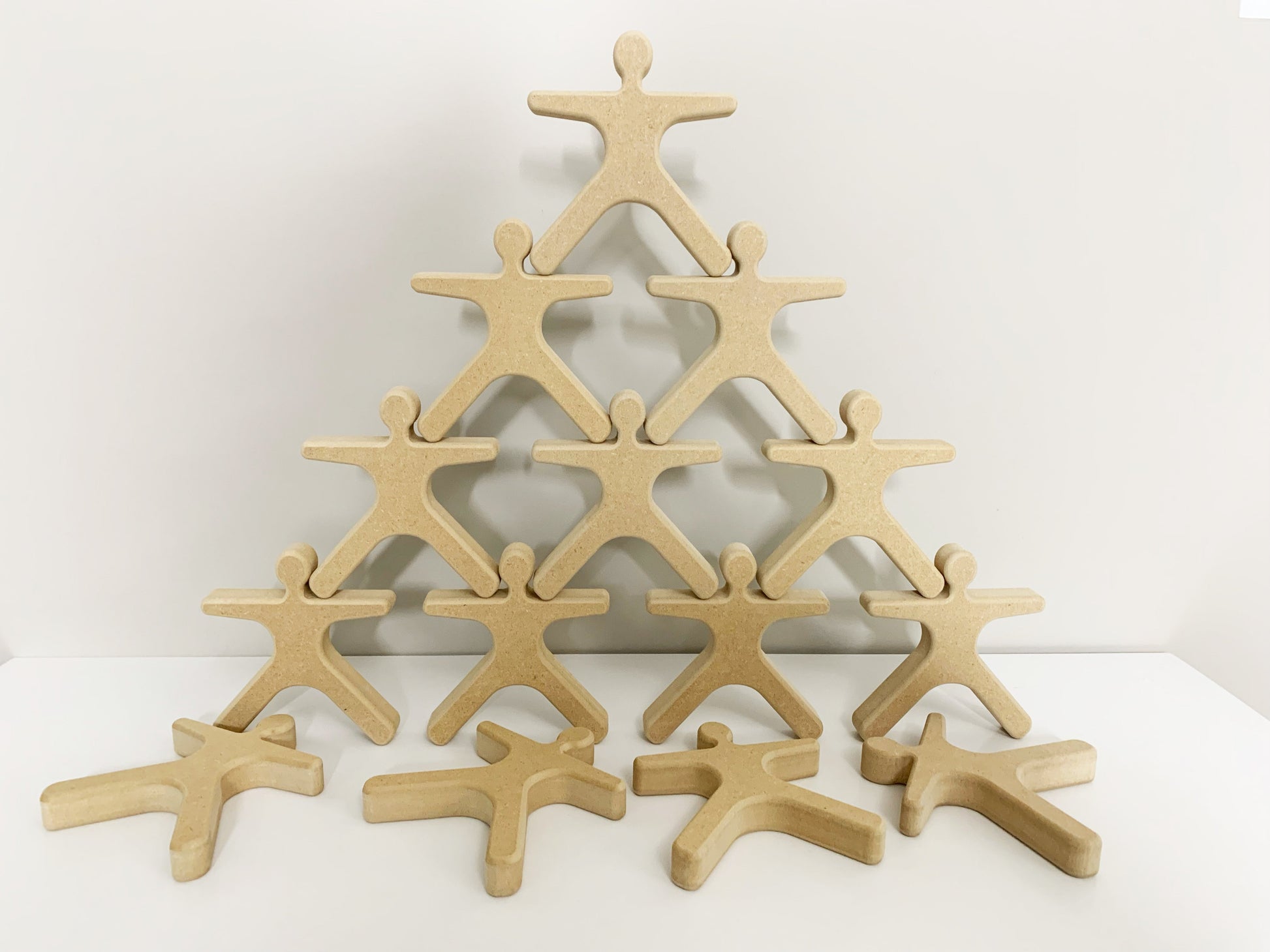 Wooden cutout figures stacked in a pyramid shape activity for seniors