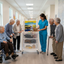 Caregiver in blue with Sunshine Cart  showing items to seniors in hallway 