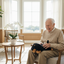 Happy senior male elderly holding clean dachshund therapy pet without letters on his lap in beautiful room