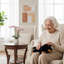 Happy senior woman holding clean dachshund therapy pet on her lap in beautiful room
