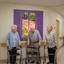 Seniors admiring faux shutter mural in facility hallway