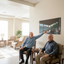 Two elderly men in a living room with a cabin mural on the wall