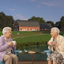 Two women talking with coffee in blue Adirondack chairs