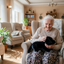 woman-holding-smaller-black-labrador-warming-therapy-pet